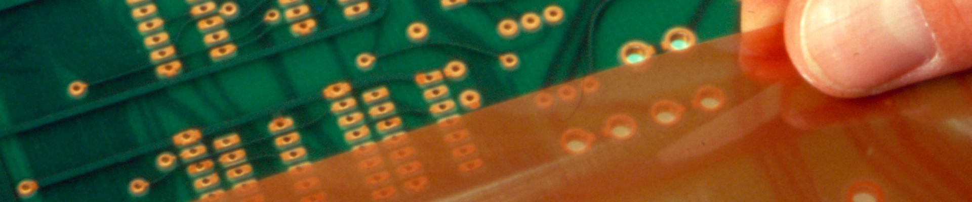 Los dedos del hombre aplican una película protectora adhesiva sensible a la presión a una tarjeta de circuito electrónico. 