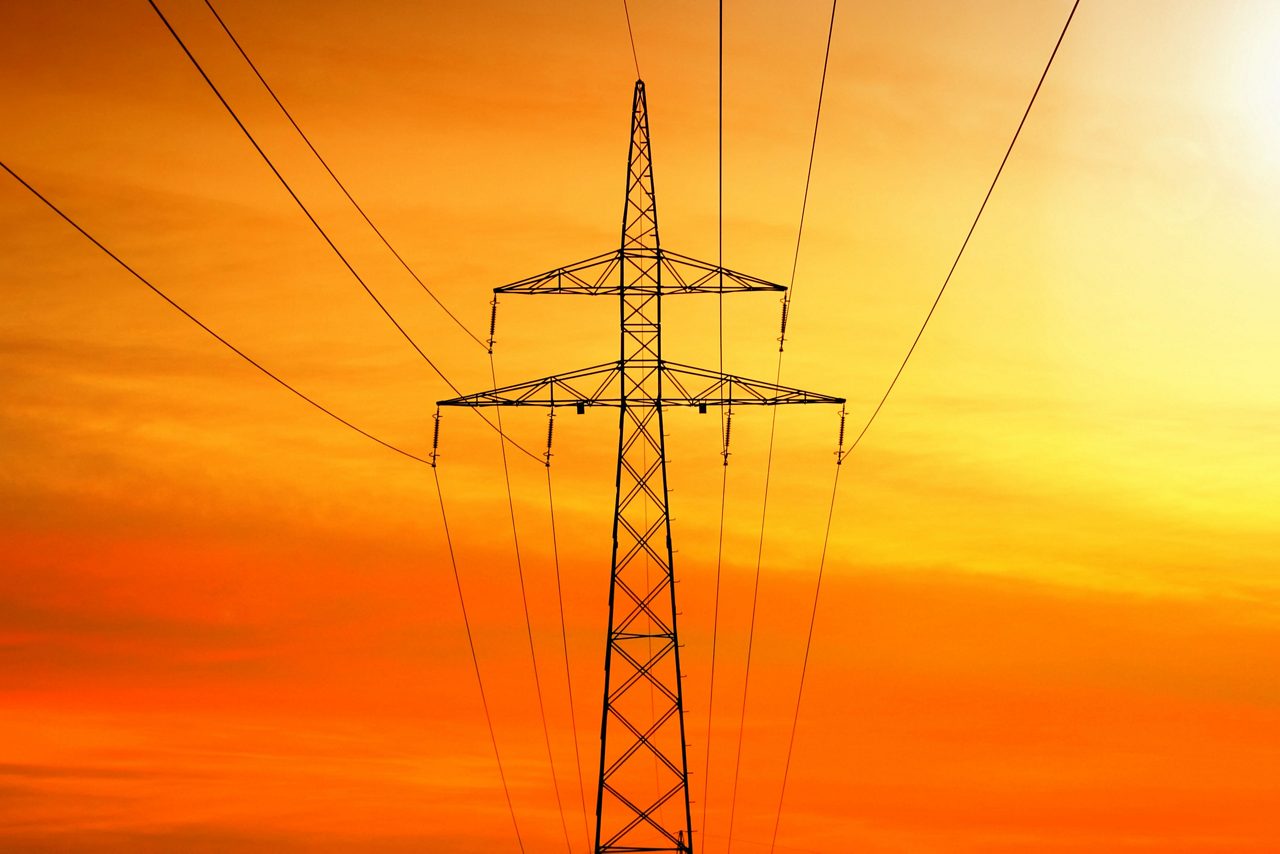 Transmisión de energía eléctrica con torre al atardecer