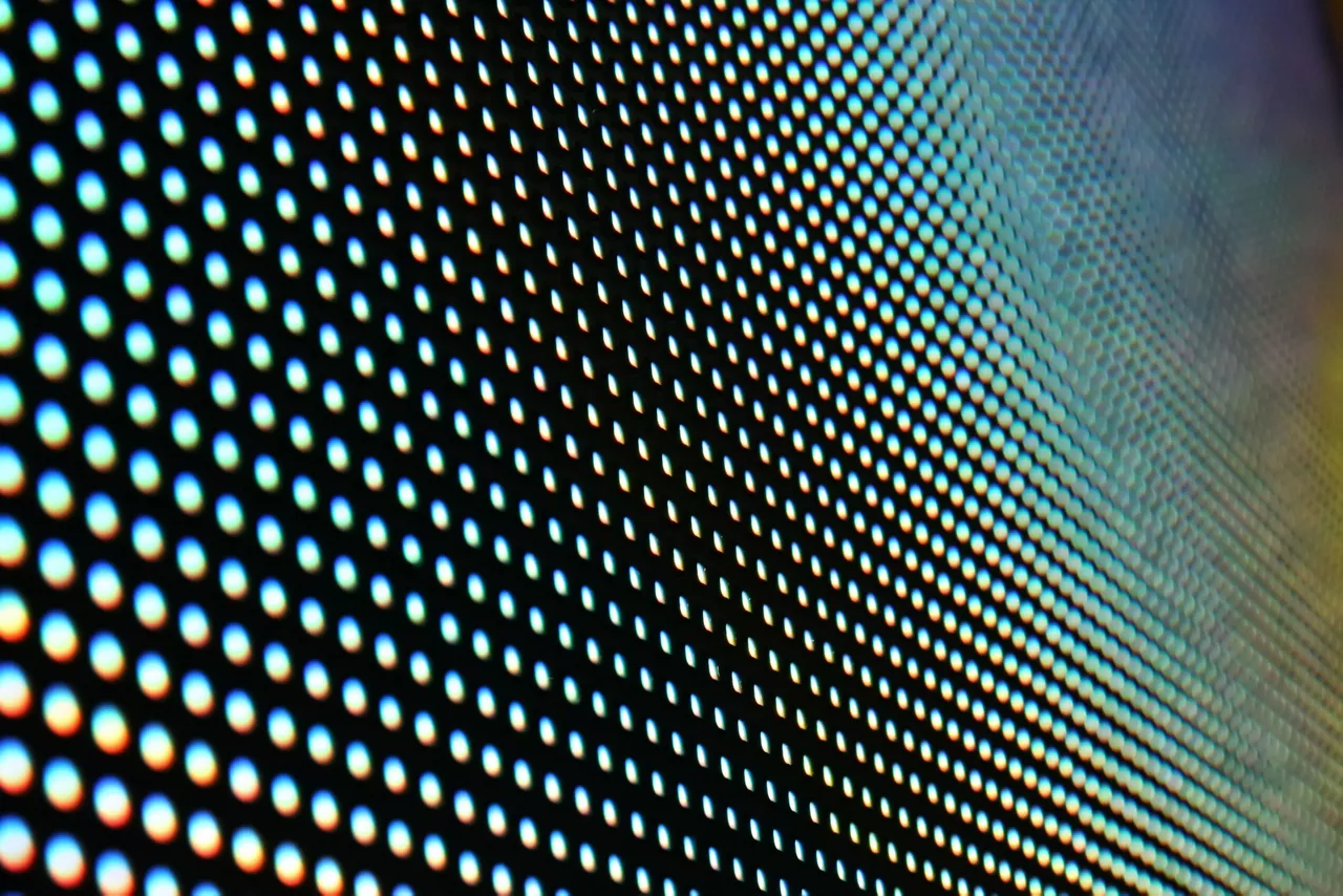 The surface of an LED screen with defocused SMD LED bulbs.