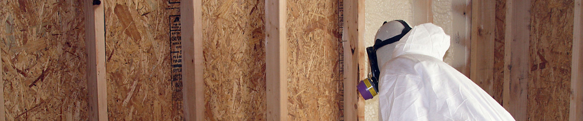 Man applying spray foam insulation with blower