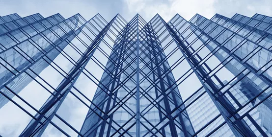 Looking up at the glass facade of a modern office building