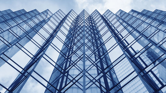 Looking up at the glass facade of a modern office building. / Shutterstock Image #387068884
