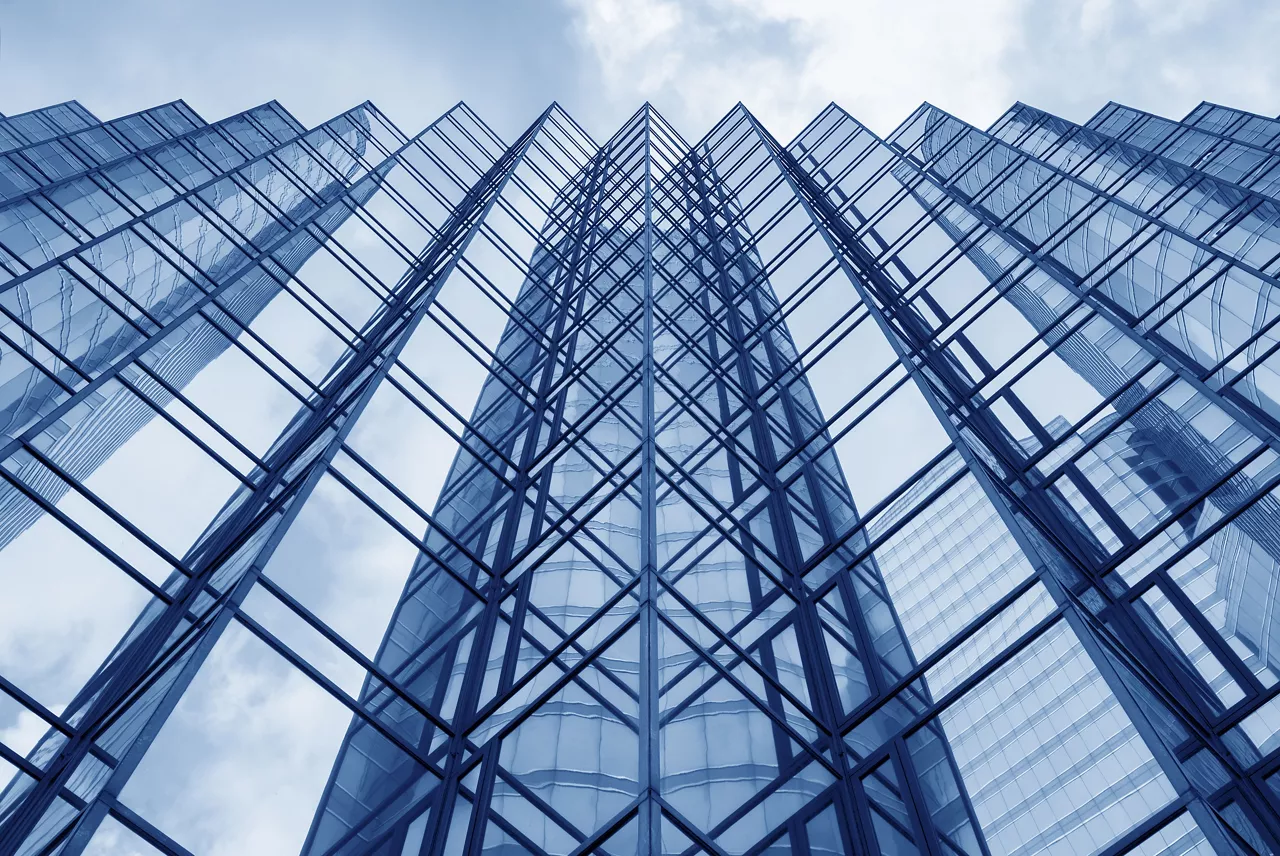 Looking up at the glass facade of a modern office building