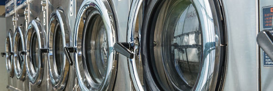 Industrial laundry machines in launderette.