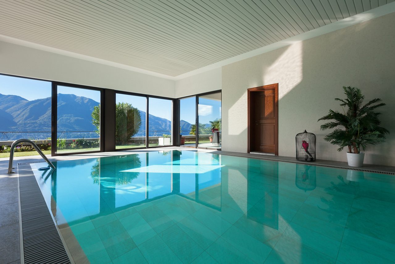 Área de la piscina cubierta con ventanas de vidrio del piso al techo