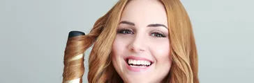 Portrait of young beautiful girl doing hairstyle at home