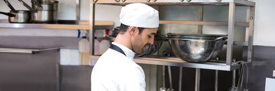 Kitchen cook cleaning plates after service.