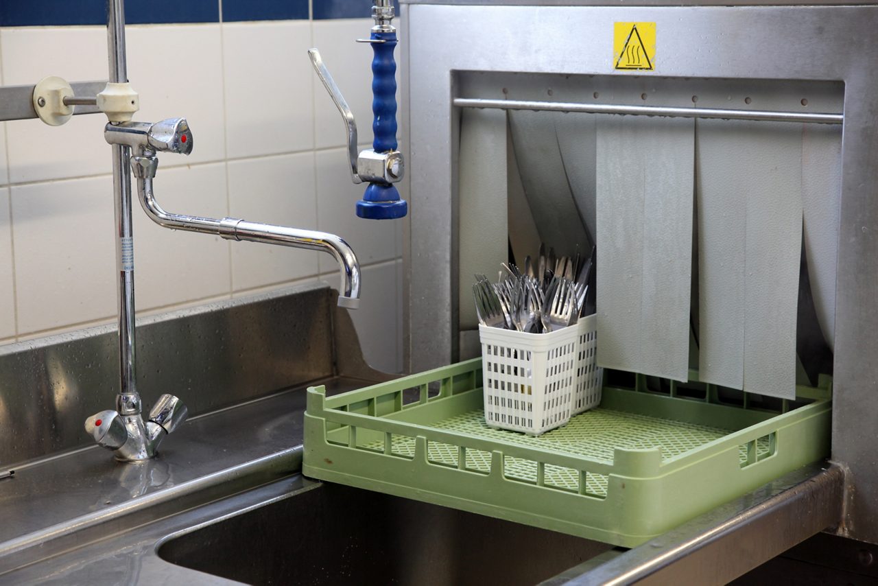 Industrial dishwasher running a load of silverware.