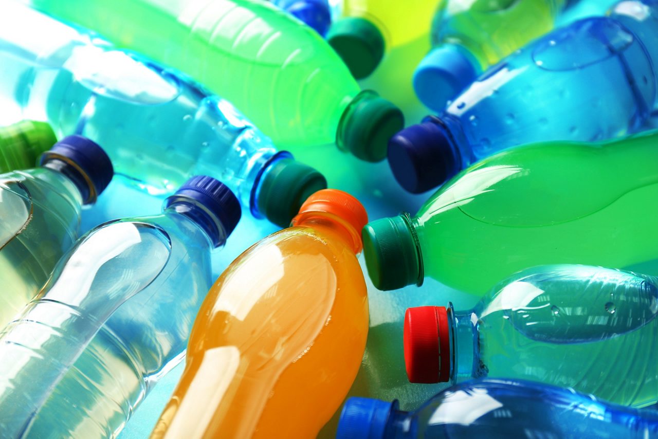 Varias botellas de plástico que contienen agua, así como bebidas de color naranja y verde
