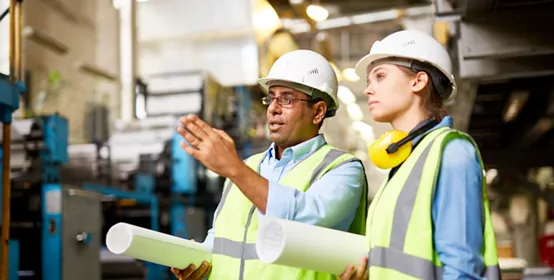 Engineers in hard hats working together at a factory