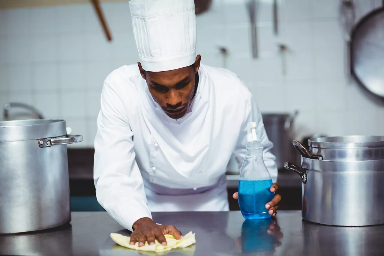 Chef cleaning kitchen surface