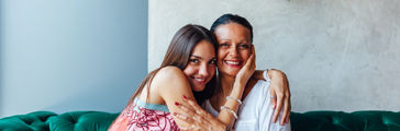 Mother and daughter embracing. Aged woman and her adult daughter drinking coffee at cafe. Mothers day.