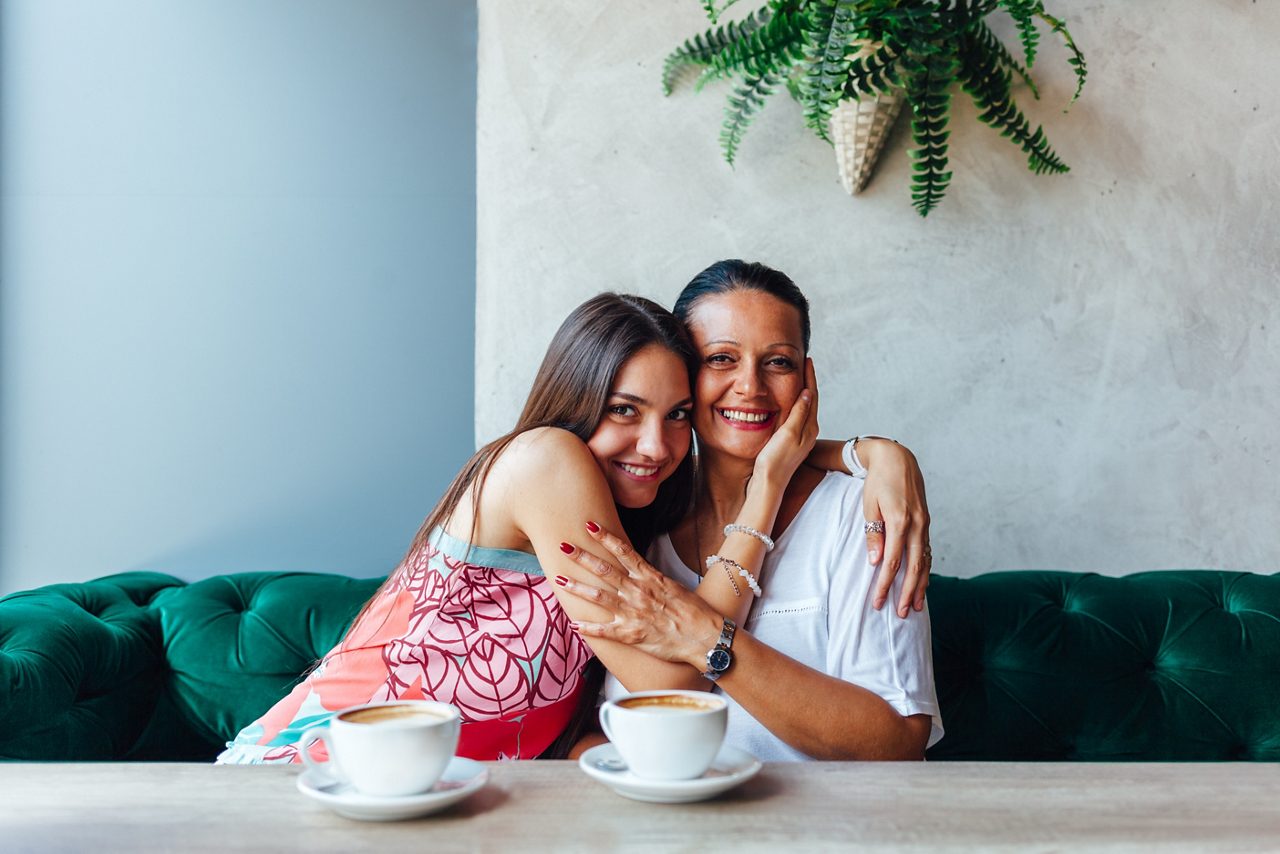 Mujer de edad y su hija adulta tomando café