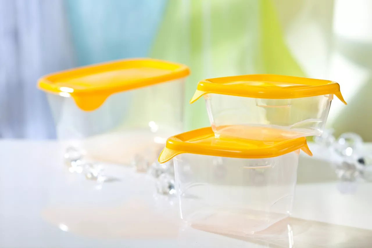 Empty clear plastic food containers with yellow lids