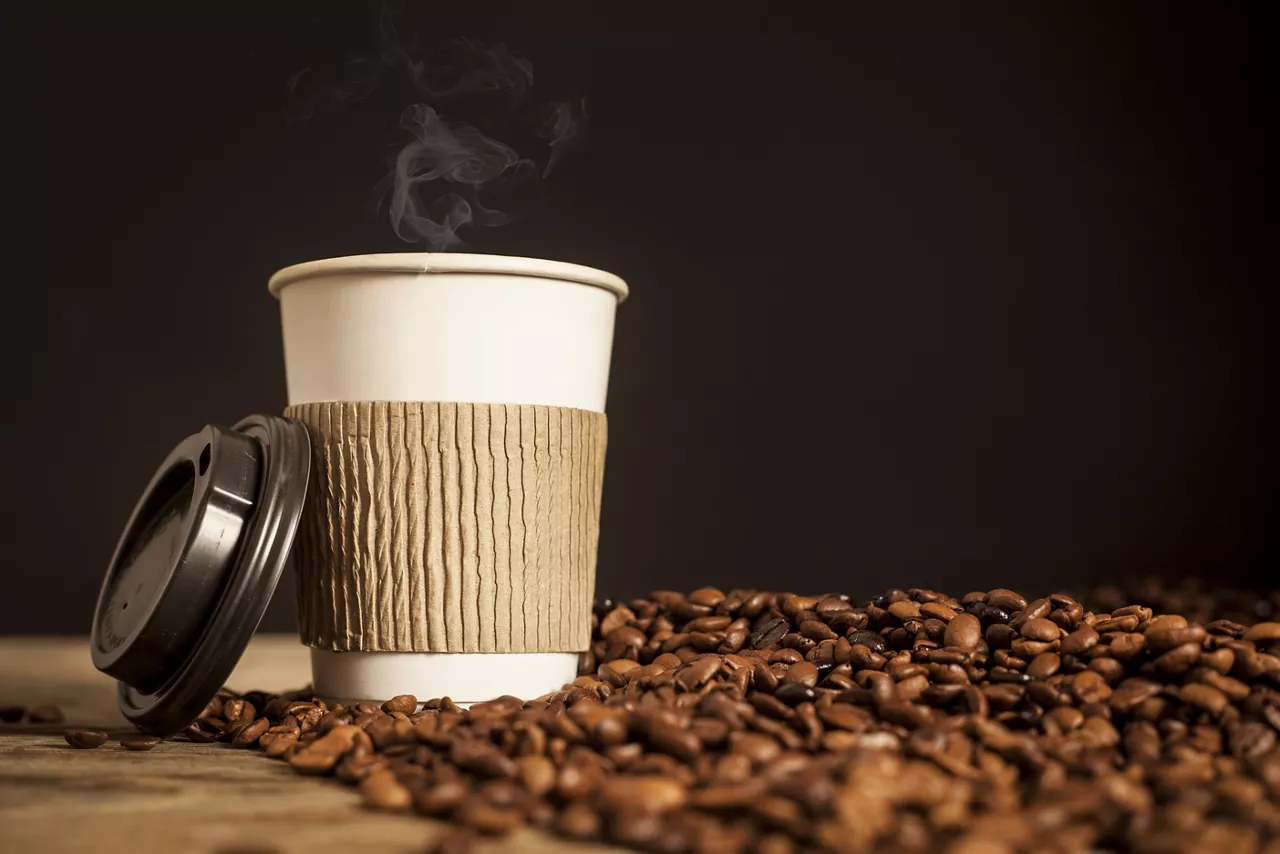 Paper cup of coffee on black background