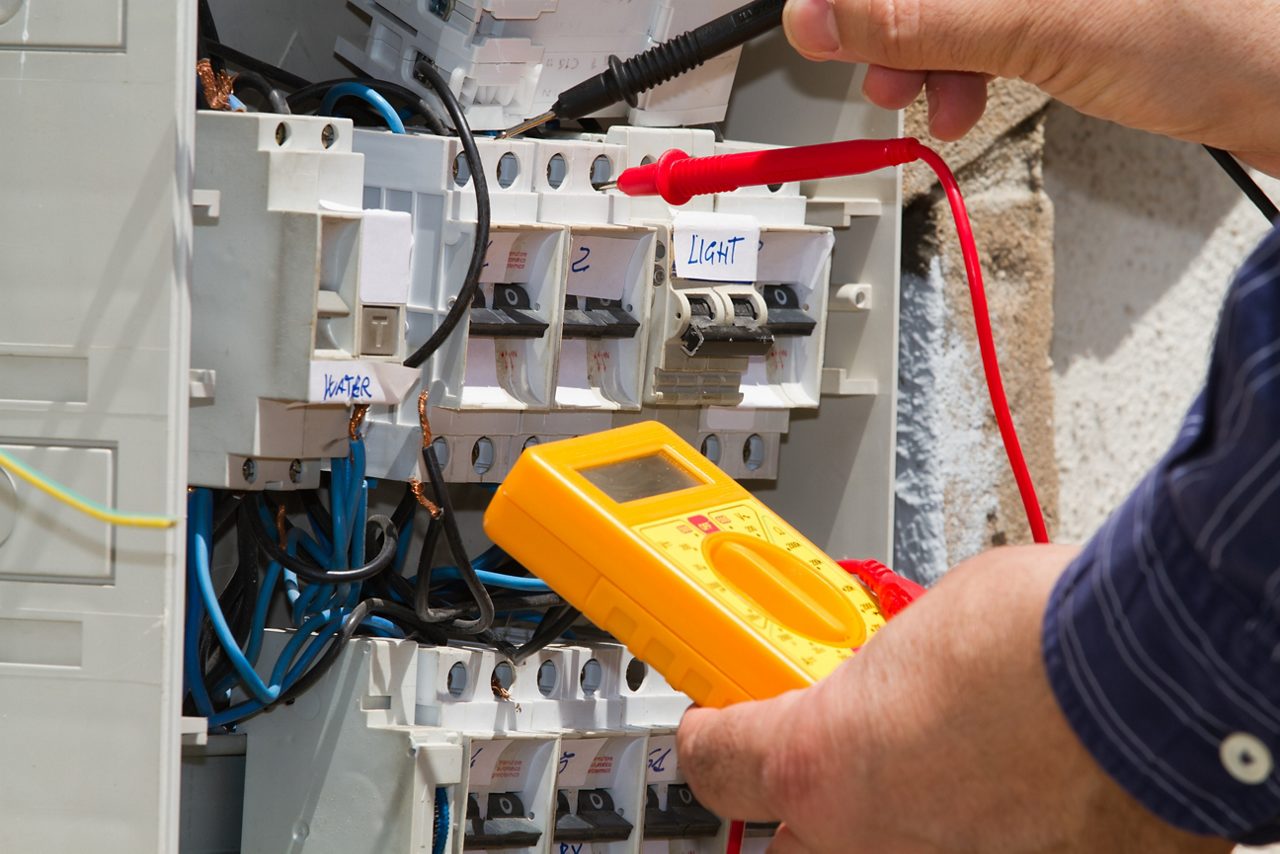 Eletricista trabalhando em painel elétrico