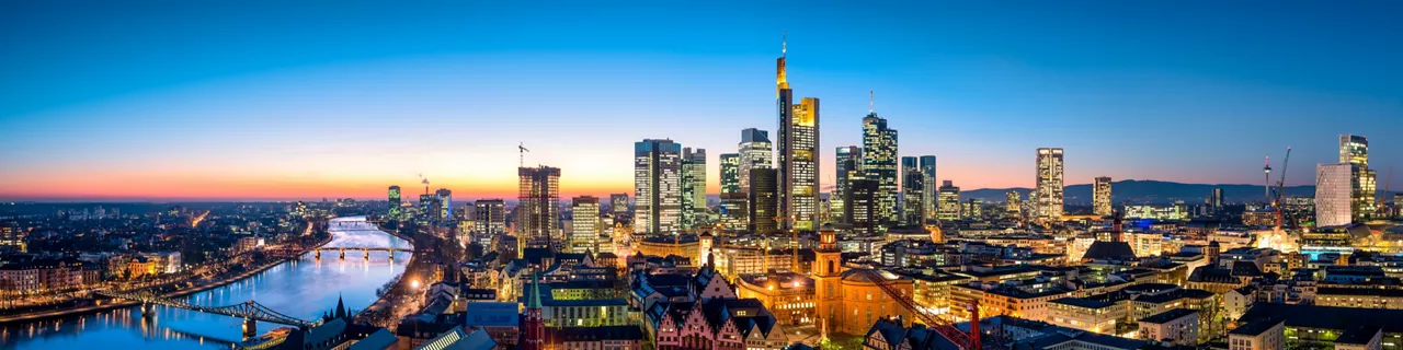 Panoramic aerial view of city skyline with river and bridges at dusk or sunset