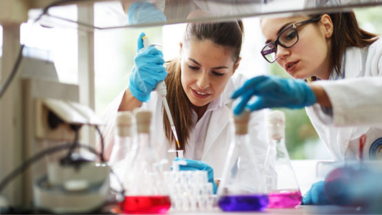 Two young female scientist doing experiments in lab.