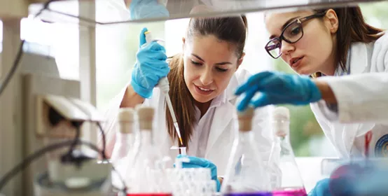 Two young female scientist doing experiments in lab.