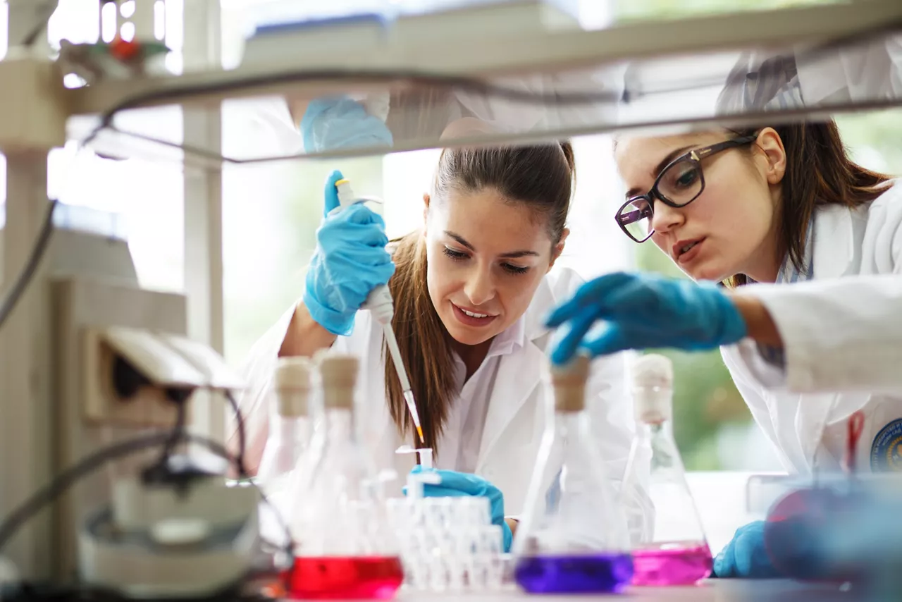 Two young female scientist doing experiments in lab.