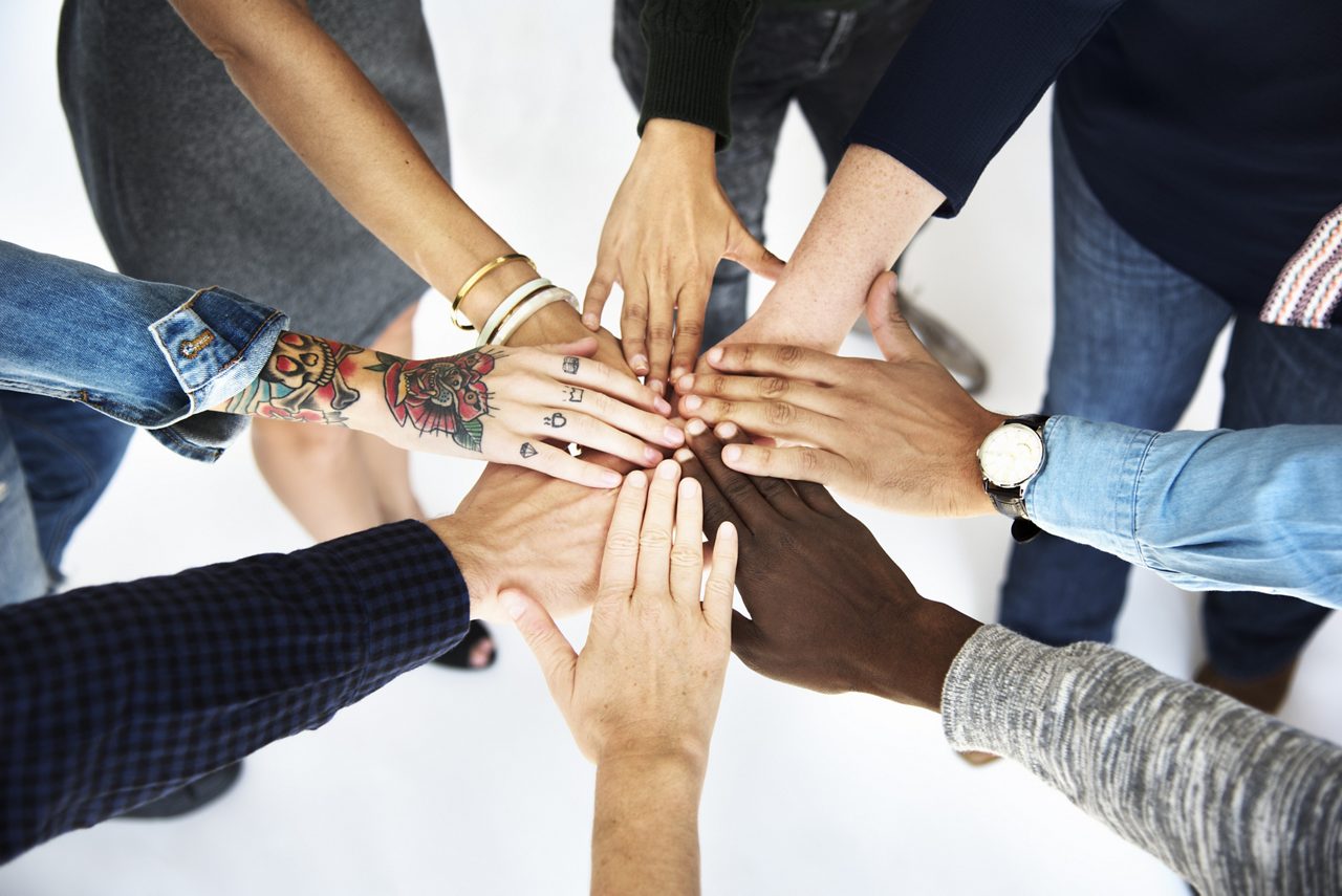 Oito mãos de trabalho em equipe multirraciais