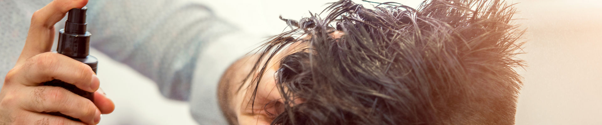 Using hairspray to style a woman’s hair