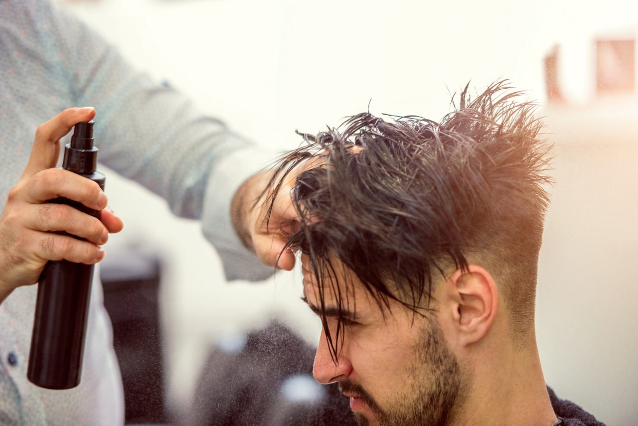 Usar spray para pentear os cabelos de uma mulher