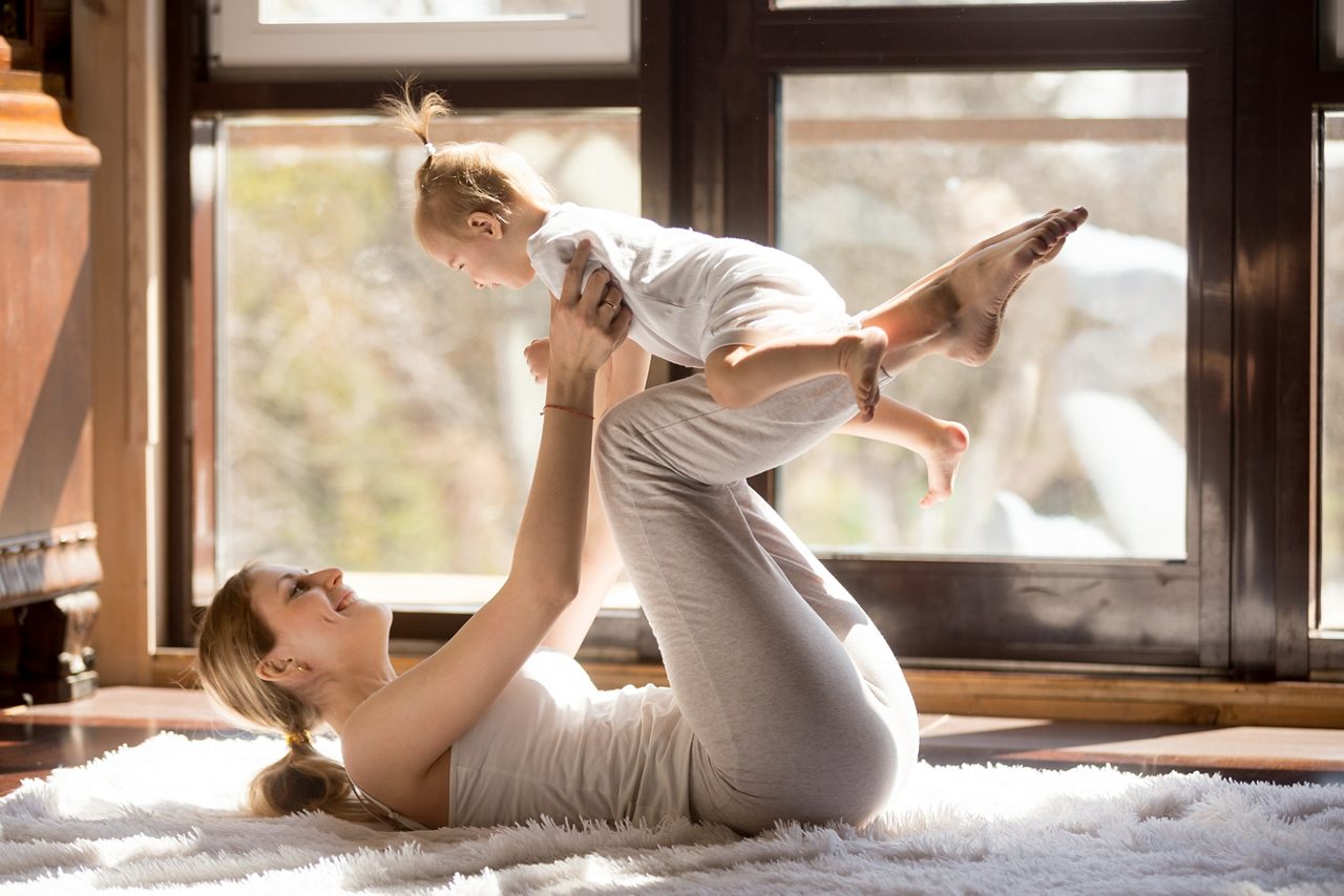 Mãe se exercitando e brincando com o bebê