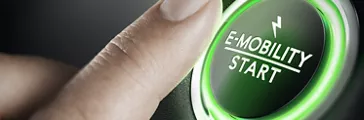 Man pushing green car button. Concept of e-mobility. Composite image between a hand photography and a 3D background.