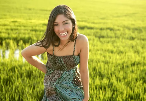 Beautiful brunette indian young woman in the green rice fields meadow