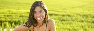 Beautiful brunette indian young woman in the green rice fields meadow