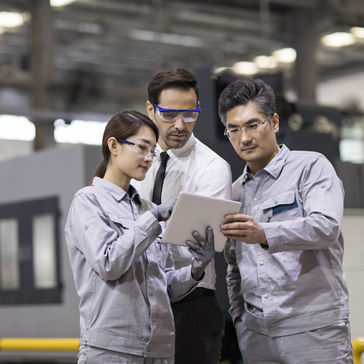 Empresario e ingenieros hablando en la fábrica