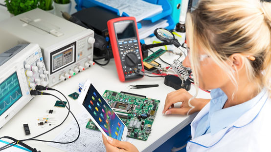 Young female digital electronic engineer using tablet computer PC in the laboratory