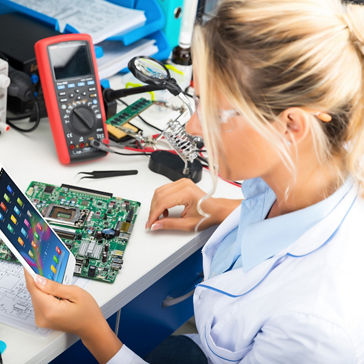 Young female digital electronic engineer using tablet computer PC in the laboratory