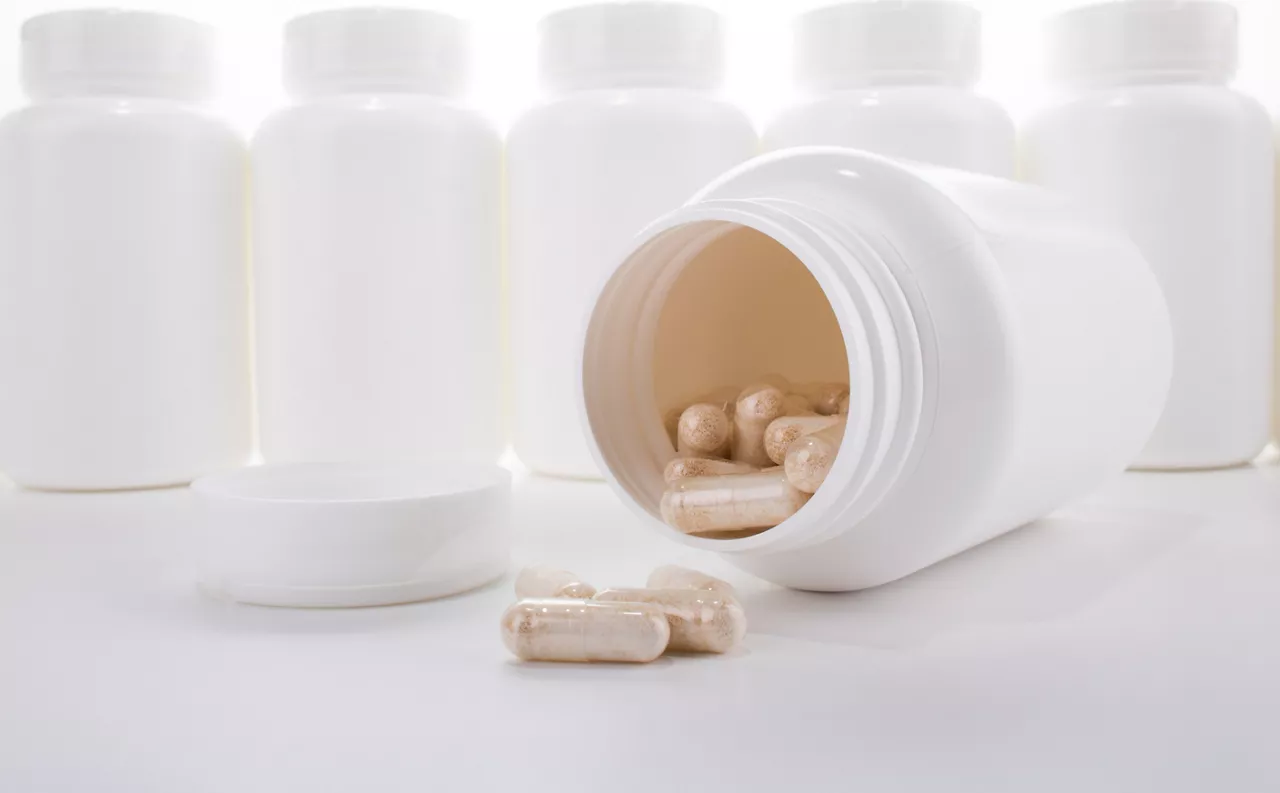 Generic pill bottles and capsules isolated on white background.