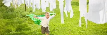  Little boy running along a clothesline