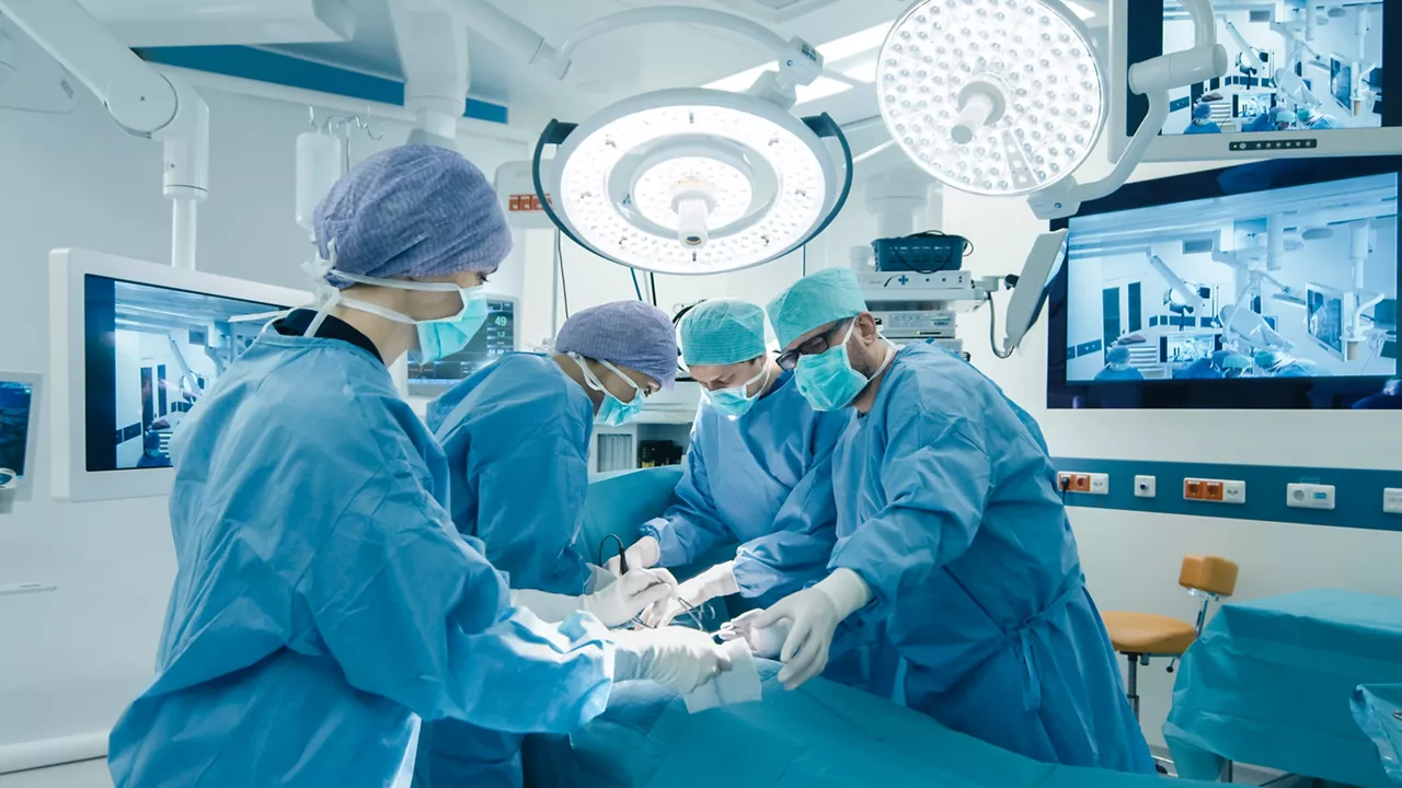 Medical team performing surgical operation in bright modern operating room