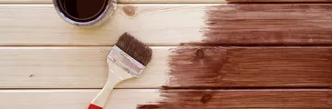 Varnishing a wooden shelf by paintbrush