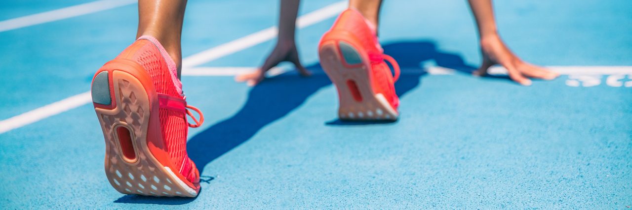 Sprinter à espera do início da corrida em pistas de corrida no estádio ao ar livre