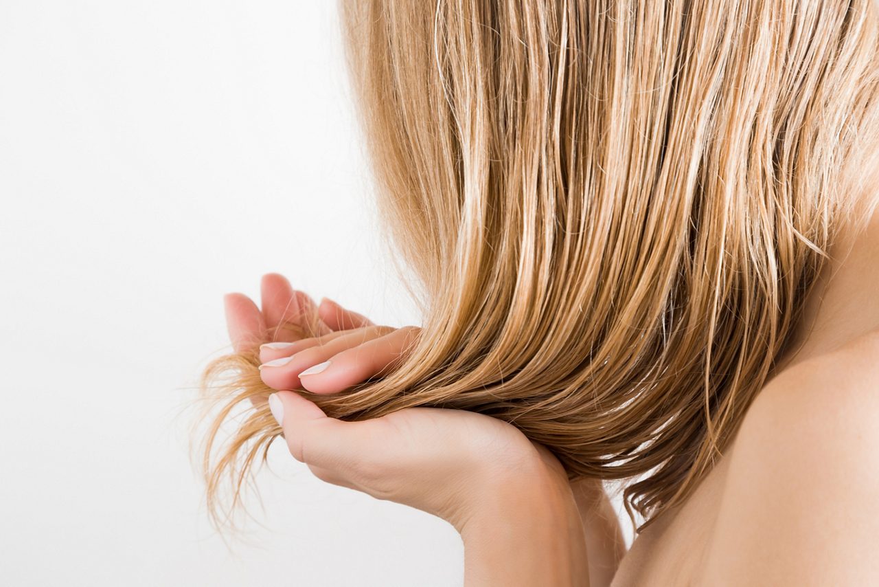 Mujer joven con la mano tocándose el cabello 