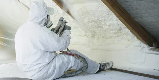 spray polyurethane foam for roof - technician spraying foam insulation