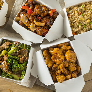 Comida chinesa exibida em embalagens encaixotadas para viagem 