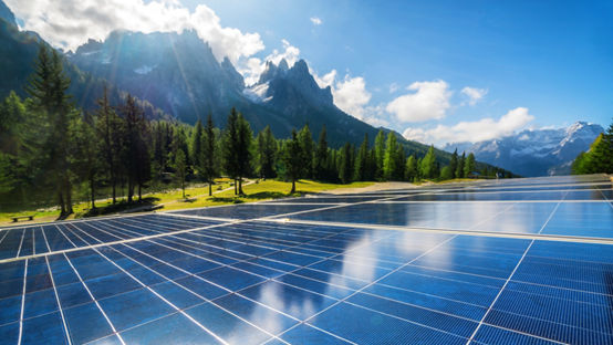 Solar cell panel in country landscape against sunny sky and mountain 