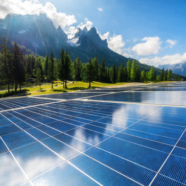Solar cell panel in country landscape against sunny sky and mountain 