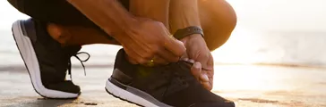 Person tying laces on their casual shoes