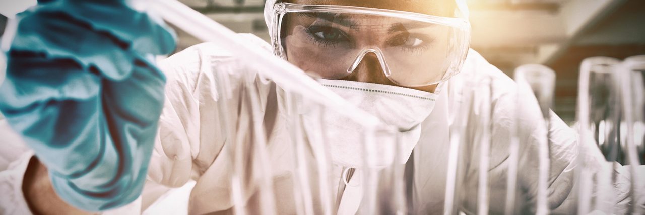 Cientista feminino usando equipamento de segurança de laboratório fazendo um experimento