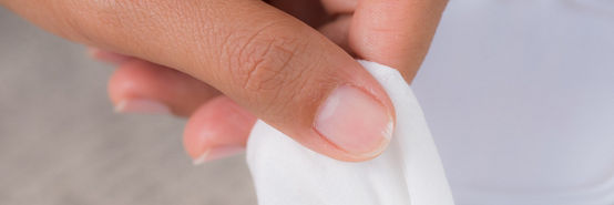 Mão de mulher segurando lenços de limpeza do pacote