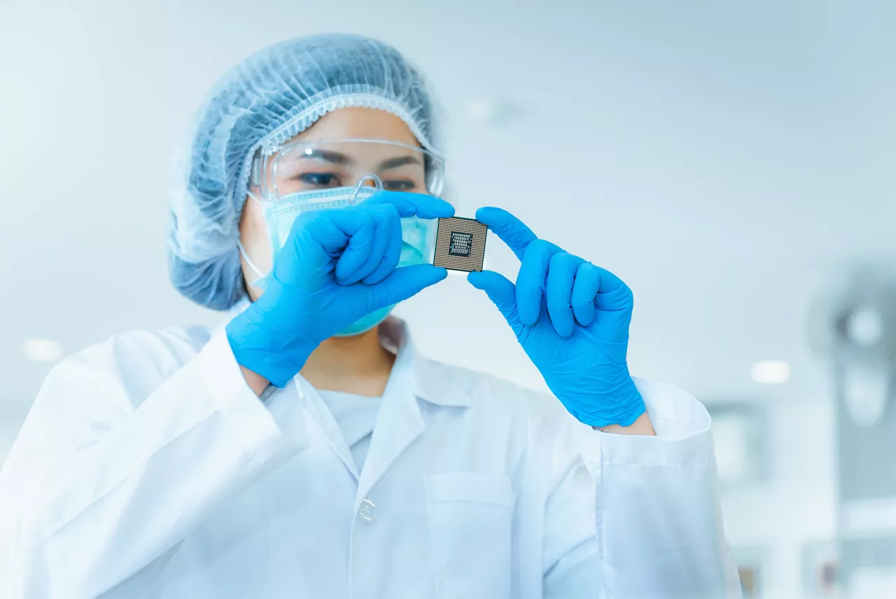 Portrait of electronics engineer is holding CPU's computer for examination.