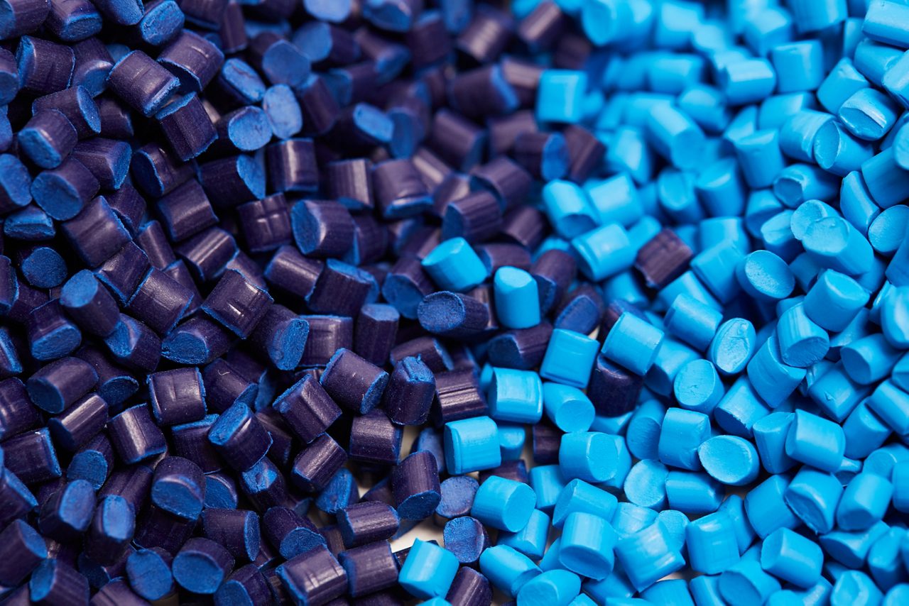 Closeup of a two stacks of blue plastic polypropylene granules on a table