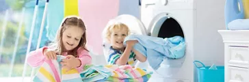 Children in laundry room with washing machine or tumble dryer